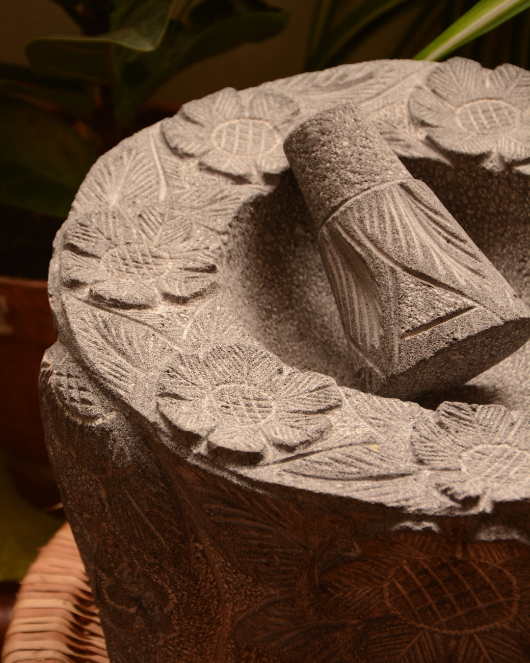 Molcajete labrado de piedra volcánica con calaveras y flores.